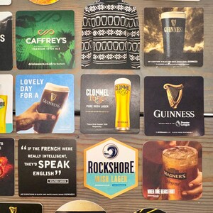 Op de afbeelding: Een verzameling bierviltjes met verschillende merken, waaronder Guinness, Magners en Murphy's. De bierviltjes tonen logo's, tekst en afbeeldingen die verband houden met Iers bier en cider. Sommige hebben citaten.