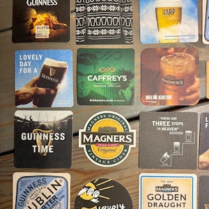 Puede incluir: Un conjunto de posavasos cuadrados y redondos con logotipos y marcas de varias cervezas y sidras irlandesas. Los posavasos muestran logotipos y textos de Guinness, Harp, Caffrey's y Magners. Algunos posavasos tienen im&aacute;genes de vasos de cerveza.