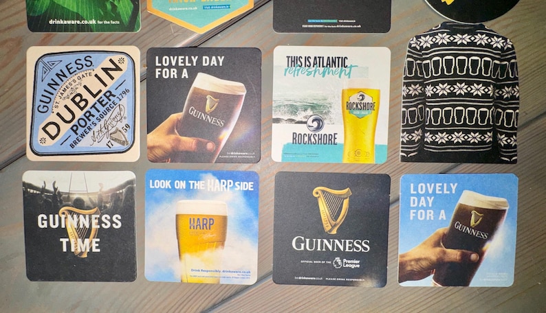 Pode incluir: Cole&ccedil;&atilde;o de bases para copos quadradas com marcas de cerveja como Guinness e Harp. Os designs incluem um padr&atilde;o de camisola a preto e branco, um copo de cerveja e o texto "Lovely Day For A".