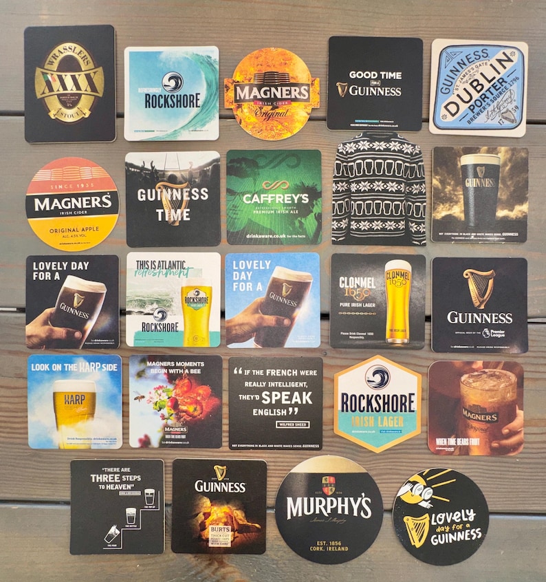 Op de afbeelding: Een verzameling vierkante en ronde drankonderzetters met logo's van verschillende bier- en cider merken. Onderzetters met logo's en tekst voor Guinness, Magners, Rockshore, Harp en Murphy's. Sommige onderzetters hebben afbeeldingen van drankjes.