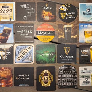 Op de afbeelding: Een verzameling bierviltjes met verschillende merken en ontwerpen. Bierviltjes zijn onder andere van Guinness, Magners, en Rockshore. Sommige viltjes hebben tekst zoals "Lovely Day for a Guinness" en "Good Time Guinness".