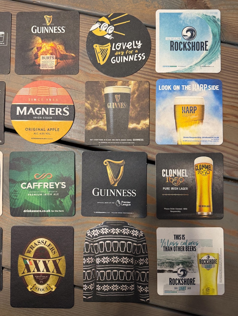 Op de afbeelding: Een verzameling bierviltjes met verschillende merken, waaronder Guinness, Magners en Rockshore. De viltjes tonen logo's en teksten zoals "Lovely day for a Guinness" en "Original Apple".