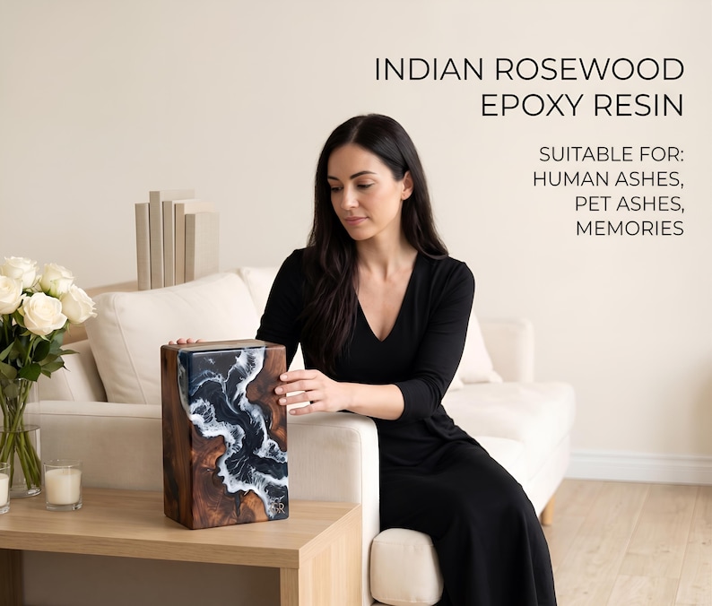 May include: A rectangular urn made of Indian rosewood and epoxy resin. The urn features a dark wood grain pattern with a blue and white wave design on the front. The text on the image reads "Suitable for: Human Ashes, Pet Ashes, Memories."
