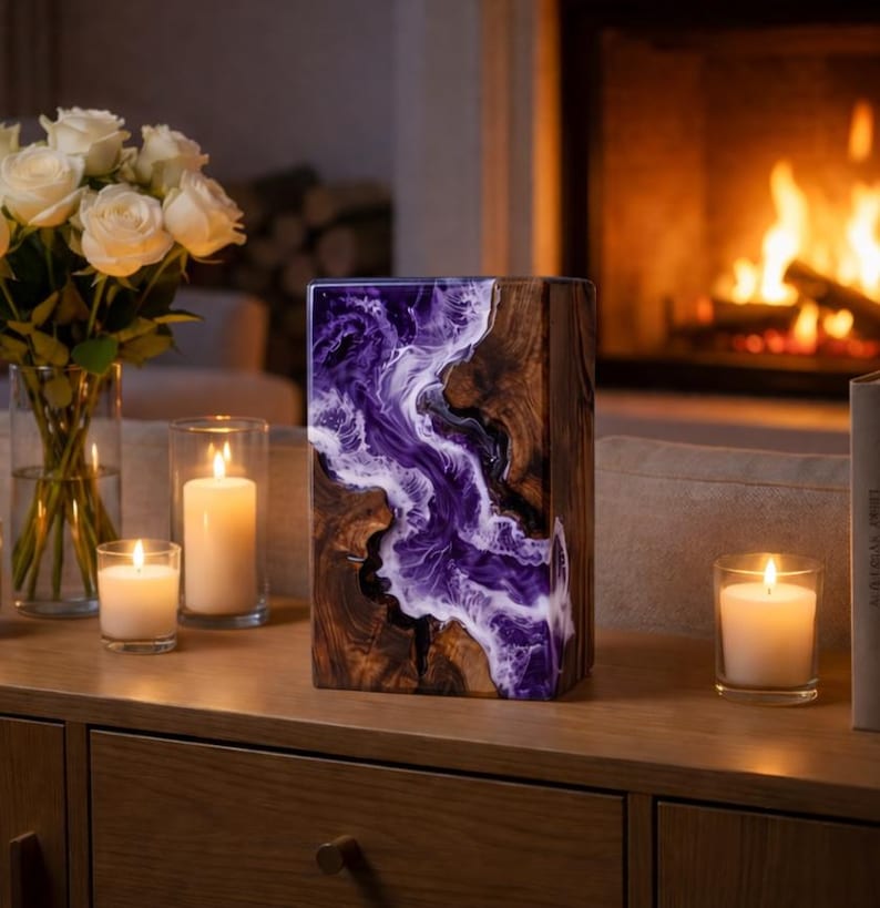 May include: A rectangular wooden art piece with a river of purple and white resin. The wood has a natural grain pattern. The piece is on a wooden surface with candles and a vase of white roses.