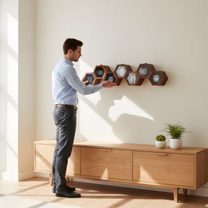 May include: Wall-mounted wooden watch box with a honeycomb design. The box is made of light and dark wood and displays several watches. The text "Wall Mounted Wooden Watch Box" is above the box.