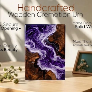 May include: Handcrafted wooden cremation urn with a unique design. The urn features a combination of dark wood and a swirling purple and white resin. The text on the image reads: "Safe & Secure Sliding Opening" and "Made From 100% Solid Wood."