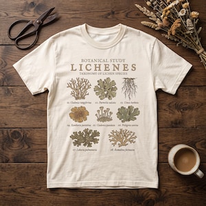 May include: A cream-colored t-shirt featuring a botanical study graphic of eight lichen species with the text "BOTANICAL STUDY LICHENES TAXONOMY OF LICHEN SPECIES" and numbered labels from 01 to 08 identifying each specific lichen type.