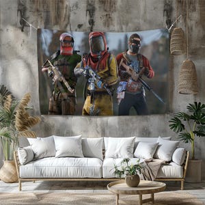 May include: A wall hanging depicting three figures in tactical gear, each holding a weapon. The figures are in a forest setting, with one in a red and yellow hazmat suit. The tapestry is displayed above a white sofa.