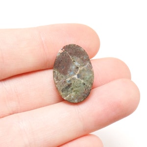 May include: Oval shaped green, brown, and white agate cabochon with a natural crack running through the center.