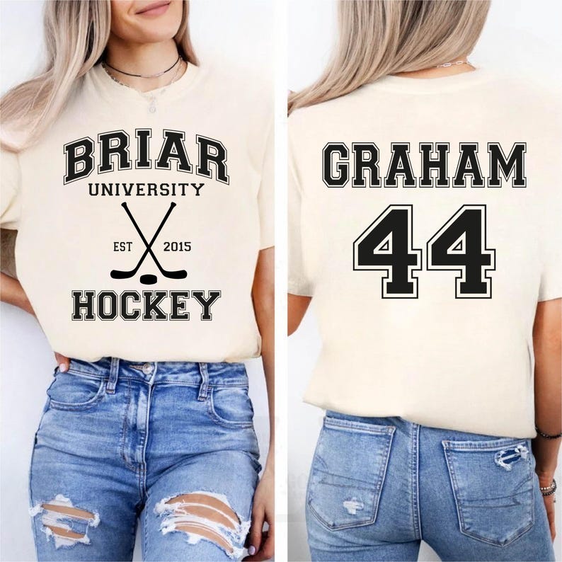 May include: Cream-colored t-shirt with the text "BRIAR UNIVERSITY HOCKEY" and crossed hockey sticks. The back of the shirt displays the name "GRAHAM" and the number "44" in black block letters.