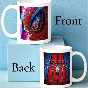 May include: White ceramic mug featuring a close-up of Spider-Man's mask on the front, with red and black detailing. The back of the mug displays the Spider-Man suit design in red, blue, and black. The word "Front" and "Back" are printed on the image.