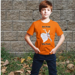 Puede incluir: Una camiseta de manga corta de color naranja brillante con un gráfico de un perro fantasma blanco con nariz roja. El texto Zero Tricks está impreso sobre el perro y el texto Only Treats está impreso debajo en una fuente negra.