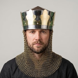 Könnte beinhalten: Eine mittelalterliche Krone mit goldfarbenen Akzenten und einem silbernen Band. Die Krone wird mit einer Kettenhaube getragen. Die Person trägt ein dunkelgraues Hemd.