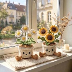 Peut inclure: Deux plantes en pot crochetées avec des visages souriants. Un pot contient des marguerites blanches à cœur jaune, et l'autre des tournesols jaunes à cœur marron. Les deux pots sont crème avec de petits pieds marron sur un tapis crocheté.