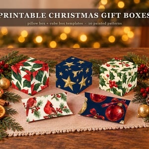 May include: Printable Christmas gift boxes featuring pillow and cube box templates with 10 painted patterns. The image displays three cube boxes and two pillow boxes with designs including red poinsettias, gold stars, holly, cardinals, and ornaments.