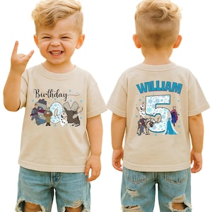 May include: A tan short-sleeved t-shirt featuring a colorful graphic design. The front of the shirt says "Birthday 5" with cartoon characters. The back of the shirt says "WILLIAM" and "5" with cartoon characters.