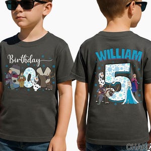 May include: Charcoal gray t-shirt with the text "Birthday Boy" and cartoon characters from a popular animated movie. The back of the shirt features the name "William" and the number "5" with snowflakes and more characters.