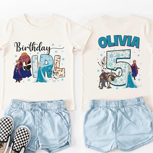 May include: Off-white t-shirt with the text "Birthday Girl" and a graphic of characters from a popular animated movie. Paired with light blue denim shorts and black and white checkered sneakers. The back of the shirt has the name "Olivia" and the number "5".