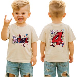 Puede incluir: Camiseta color beige con dise&ntilde;o de Spider-Man. La parte delantera muestra el nombre "PAUL" en rojo y azul, con un dise&ntilde;o de telara&ntilde;a. La parte trasera muestra el n&uacute;mero "4" rojo con gr&aacute;ficos de Spider-Man.