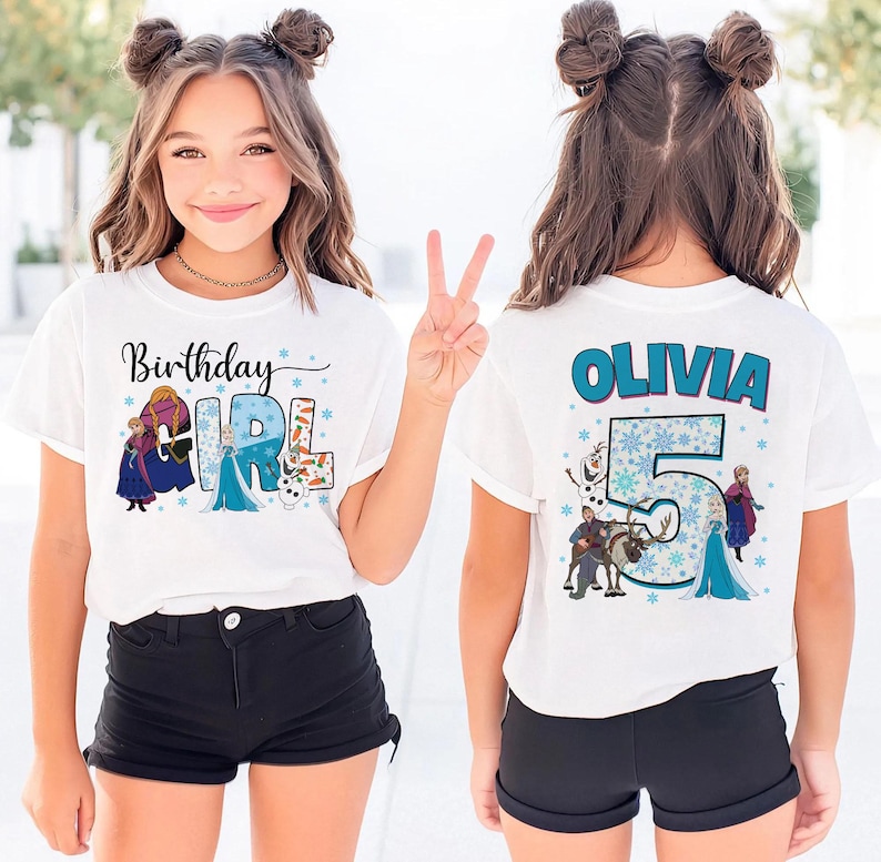 May include: White t-shirt with the text "Birthday GIRL" and a Frozen-themed design. The back of the shirt says "OLIVIA" and "5" with more Frozen characters. The shirt is worn by a young person.