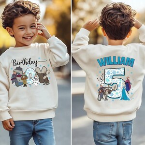May include: A cream-colored sweatshirt featuring a birthday theme. The front displays the word "Birthday" and the number "04" with cartoon characters. The back shows the name "WILLIAM" and the number "5" with more cartoon characters.