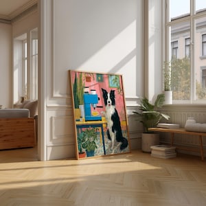 May include: A framed art print featuring a Border Collie dog standing next to a blue espresso machine. The artwork has a pink background with potted plants and a yellow table. The dog is black and white.