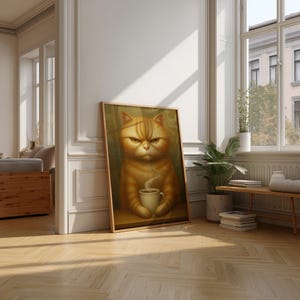 Puede incluir: Un cuadro enmarcado con un gato atigrado naranja con expresión enfadada, sosteniendo una taza de café. La obra de arte está en un marco de madera y está apoyada contra una pared blanca en una habitación con suelo de parquet. El gato tiene rayas y la taza de café emite vapor.