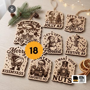 May include: A collection of eight wooden Christmas ornaments featuring engraved illustrations of skeletons, a snowman, Santa Claus, and a nutcracker with humorous text including Check Out My Balls, Jolly AF, Let's Get Elfed Up, Frosted, Festive AF, Kissmyass, Santa's Favorite Ho, and I Want Your Nuts.
