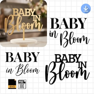 May include: A gold-colored wooden cake topper that reads "BABY in Bloom" in a mix of block and cursive fonts. The topper is on a small, round, white cake stand. The image also shows the text "BABY in Bloom" in black.