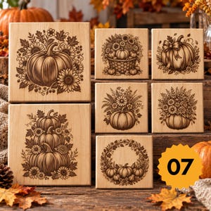 May include: Six square wooden blocks featuring laser-engraved autumn designs. The illustrations include pumpkins, sunflowers, floral arrangements, and a wreath. A yellow star-shaped badge with the number 07 is positioned in the lower right.