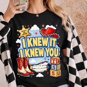 May include: A black t-shirt featuring a graphic print with a yellow sheriff badge labeled INFINITY AND BEYOND, a red cowboy hat, red and white cowboy boots, colorful alphabet blocks with T, S, 5, and a beaded necklace with the text you've got a friend in me.