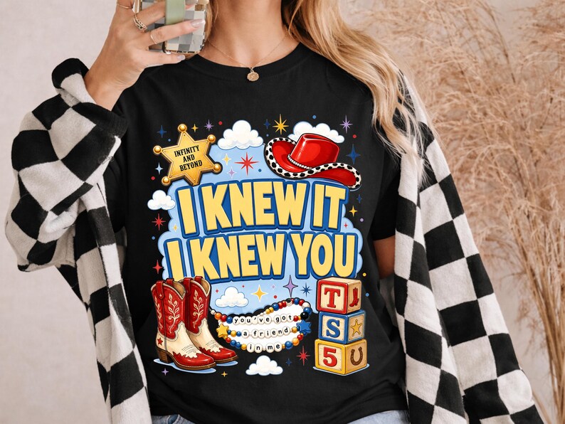 May include: A black t-shirt featuring a graphic print with a yellow sheriff badge labeled INFINITY AND BEYOND, a red cowboy hat, red and white cowboy boots, colorful alphabet blocks with T, S, 5, and a beaded necklace with the text you've got a friend in me.