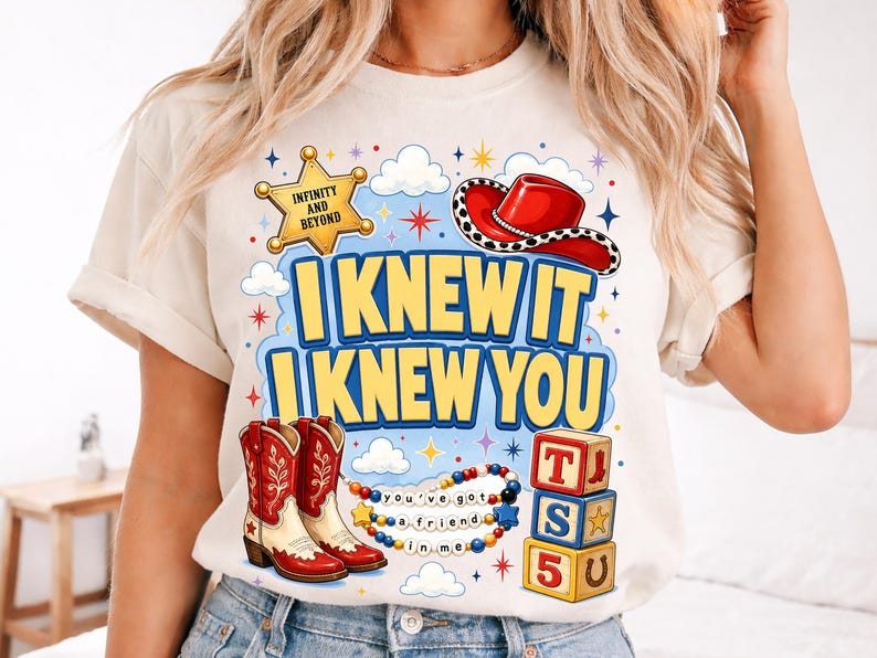 May include: A cream-colored t-shirt featuring a graphic print with a yellow sheriff badge labeled INFINITY AND BEYOND, a red cowboy hat, red and white cowboy boots, a beaded necklace with the text you've got a friend in me, and alphabet blocks.