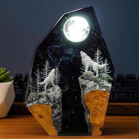 A glowing wolf howling at the moon inside a handcrafted resin diorama — legitimately atmospheric fantasy table art with respectable demand.