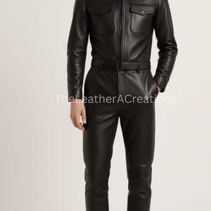 May include: Black leather jumpsuit with a collared neckline, two chest pockets, and a zip-up front. The jumpsuit includes a matching belt and fitted pants. The LeatherACreations text is visible on the image.