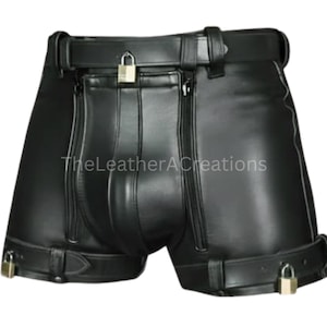 May include: Black leather shorts with a belt, zippers, and padlocks. The shorts have a front pouch, side zippers, and a belt with a buckle. The shorts are designed with a focus on security and style.