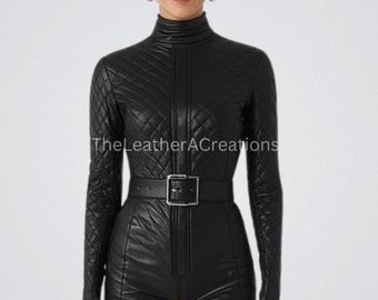 May include: A black leather jumpsuit with a quilted pattern, long sleeves, and a high neckline. The jumpsuit features a front zipper, a belt with a square buckle, and short shorts. The text "TheLeatherACreations" is visible.