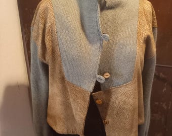 Peut inclure: Veste unique de style patchwork avec un col montant. La veste présente une combinaison de tricot bleu clair et de panneaux beiges texturés. Elle se ferme avec de petits boutons ronds. Les manches sont longues et le design est d'inspiration vintage.
