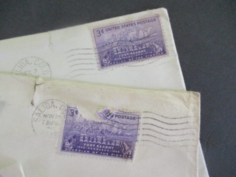 Op de afbeelding: Close-up van twee vintage enveloppen met paarse 3-cent Fort Kearny postzegels. De enveloppen zijn gestempeld met poststempels uit Salida, Colorado. De tekst "GUARDIAN OF THE PIONEER" is zichtbaar.