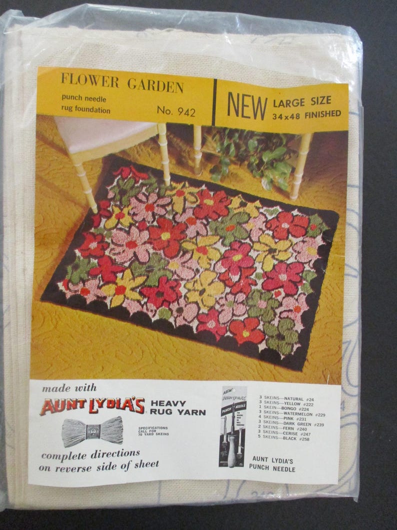 May include: A new, large-size punch needle rug foundation kit. The kit features a floral design with red, pink, yellow, and green flowers on a black background. The finished rug size is 34 x 48 inches. The kit includes Aunt Lydia's heavy rug yarn.