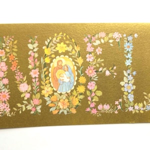 Puede incluir: Una tarjeta navide&ntilde;a dorada con la palabra "NOEL" escrita en arreglos florales. La letra "O" presenta una imagen religiosa de Mar&iacute;a, Jos&eacute; y el ni&ntilde;o Jes&uacute;s. La tarjeta est&aacute; decorada con flores rosas, amarillas y azules.