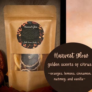 May include: A brown paper pouch containing a Harvest Glow simmer pot kit with dried citrus slices visible through a clear window. The circular label features botanical illustrations and instructions, while a dark circle displays the text Harvest Glow golden scents of citrus, oranges, lemons, cinnamon, nutmeg, and vanilla.