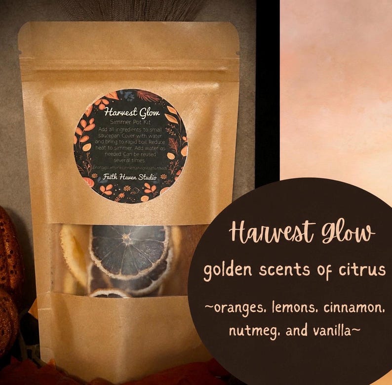 May include: A brown paper pouch containing a Harvest Glow simmer pot kit with dried citrus slices visible through a clear window. The circular label features botanical illustrations and instructions, while a dark circle displays the text Harvest Glow golden scents of citrus, oranges, lemons, cinnamon, nutmeg, and vanilla.