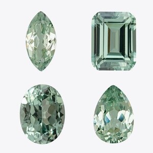 May include: Four faceted gemstones in various shapes: marquise, emerald cut, oval, and pear. The gems are a pale green color and are set against a white background. The cuts display multiple facets.