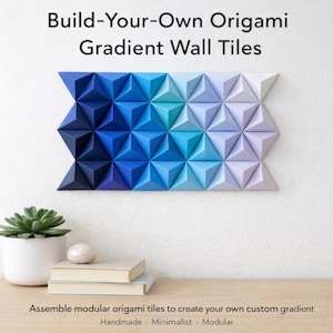 May include: A wall-mounted origami art piece with a gradient of blue hues. The geometric design is made of triangular tiles, transitioning from dark to light shades. The text reads "Build-Your-Own Origami Gradient Wall Tiles."