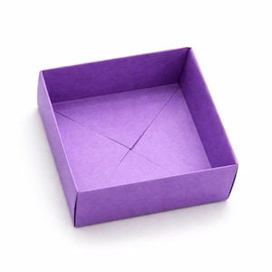 May include: A square, open purple box with a folded base. The box is made of paper and has a simple design. The box is empty and sits on a white background.