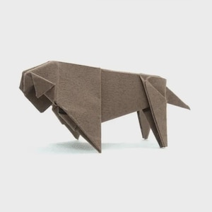 May include: A brown origami lion figure, crafted from folded paper. The lion is depicted in a side profile, showcasing its head, body, and legs. The paper has a textured appearance, and the lion is set against a plain background.