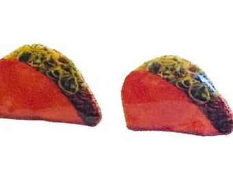 May include: Two red, wedge-shaped food items with a textured, yellow-green topping. The food items are on a white background. The food items appear to be a type of pastry or dessert.