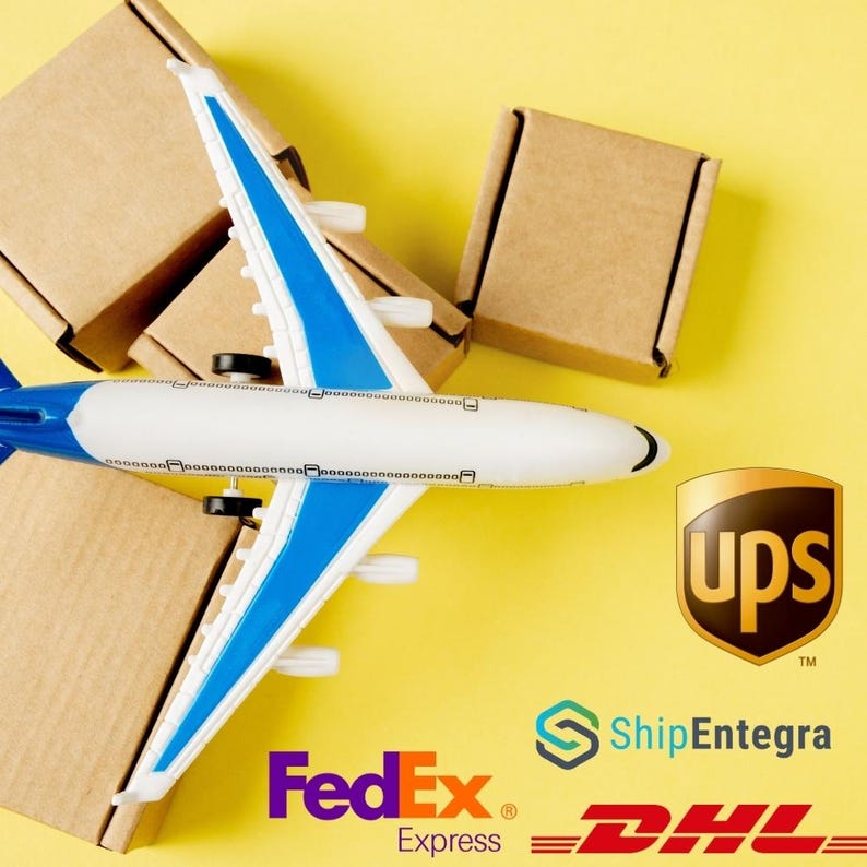 May include: A toy airplane with blue and white wings rests on top of several small brown cardboard boxes. The UPS logo is visible, along with the FedEx Express, ShipEntegra, and DHL logos, all set against a yellow background.