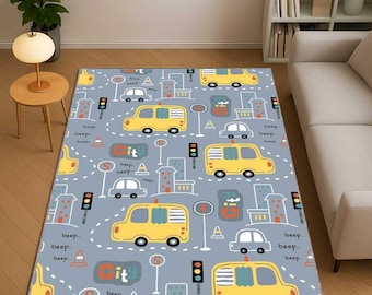 May include: A rectangular area rug with a playful city-themed design. The rug features yellow buses, cars, traffic lights, and buildings on a light blue background. The word "City" is visible, along with "beep" text.